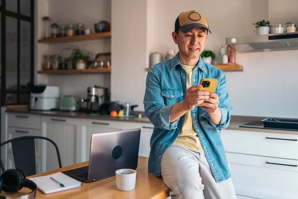 Обычный Китайский Бизнесмен Использующий Мобильный Телефон Стоящий Кухне Рядом Домашним Лицензионные Стоковые Изображения