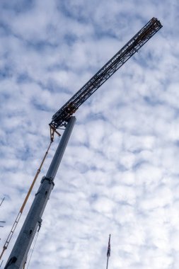 looking up at a crane with cloudy sky