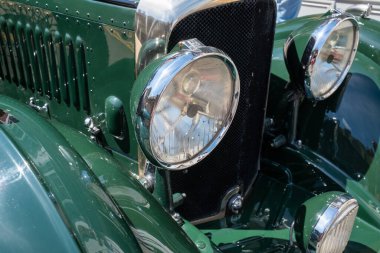Eski yeşil bir arabanın klasik farları. 