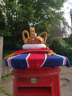 Taç giyme töreni bir posta kutusuna örgü örüyor. 