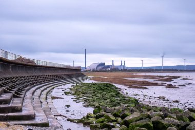 Severn beach with sea wall and green rocks clipart
