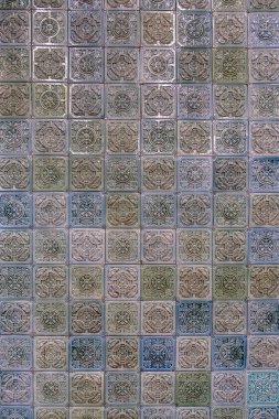 Duvarda kabartmalı renkli fayanslar var.