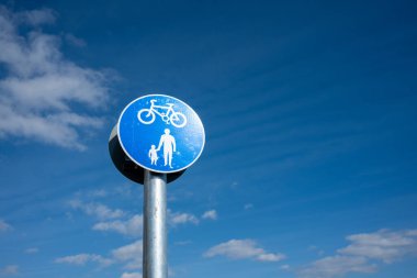 Etrafta mavi gökyüzü olan yaya bisiklet tabelası 