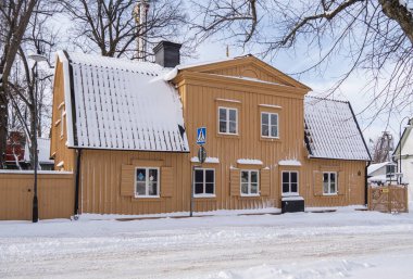 Stockholm, İsveç - 9 Mart 2023: Yolun kenarındaki eğlence parkının yanındaki turistik bir adada büyük ahşap bir ev, eski inşaat ve tipik İsveçli eski mimari.