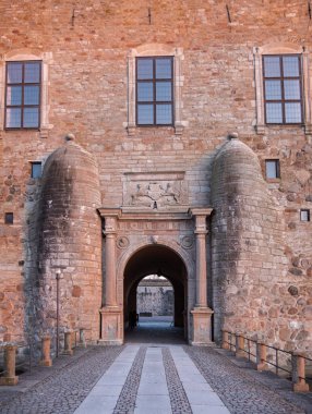 Vadstena, İsveç - 2 Nisan 2022: Vadstena 'nın ortaçağ şatosunun heybetli girişi, ana girişten önce iki özel yarımküre sütunuyla birlikte