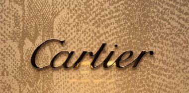 Zürih, İsviçre - 30 Aralık 2021: Kalıplaşmış altın arkaplan üzerine Cartier logosunun yakın çekimi.