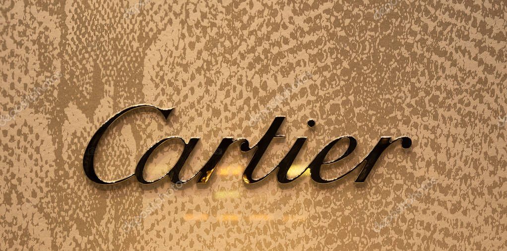Zurich, Switzerland - 30 December 2021: A close-up of the Cartier logo on a textured golden background.