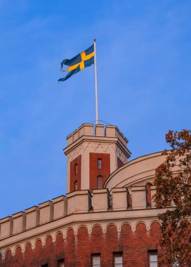 Stockholm, İsveç - 18 Ekim 2024: Kastellholmen İsveç bayrağıyla süslenmiş merkezi kuleye sahip tarihi bir binaya sahiptir..