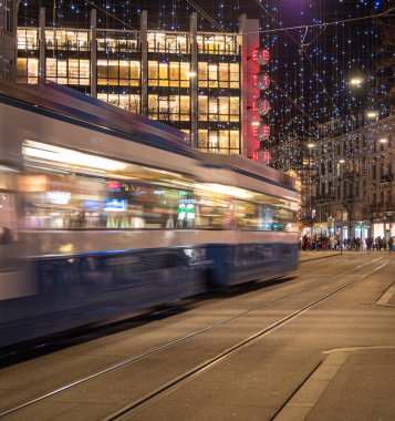 Zürih, İsviçre - 31 Aralık 2021: Bayramlarda Zürih 'in aydınlık sokaklarında süzülen şenlikli bir tramvay.