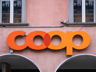 Locarno, İsviçre - 28 Aralık 2021: Bir binanın dış duvarında, dekoratif unsurları olan iki pencerenin altında parlak turuncu ve kırmızı bir 'kümes' logosu.