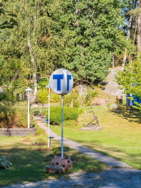 Ağaçlar ve patikalarla dolu yemyeşil bir bahçede duran klasik bir tramvay tabelası nostalji çağrıştırıyor..