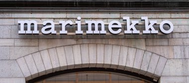 Stockholm, İsveç - 11 Mayıs 2025: 'Marimekko' markasının cesur ve modern tipografisini gösteren bir mağaza vitrininin yakın çekimi. Tabela desenli taş bir duvara monte edilmiş, mimari detaylar sergileniyor..