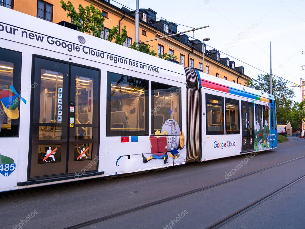 Stockholm, Sweden - June 3 2025: A colorful tram featuring advertisements for Google Cloud, showcasing various graphics and logos. The tram is parked on a city street with buildings in the background.