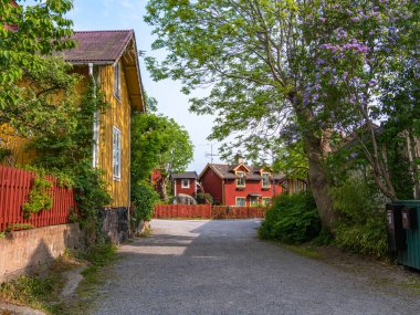 Vaxholm, İsveç - 4 Haziran 2025: Renkli ahşap evleri ve yemyeşil bahçeleri olan büyüleyici bir yerleşim yeri.