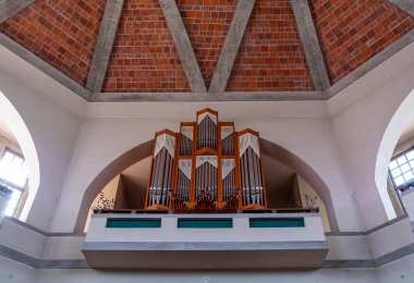 Odranci, Slovenya - 24 Temmuz 2025: Tuğla tavanlı ve kemerli pencereli bir kilisede büyük bir boru organı.