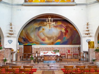 Odranci, Slovenya - 24 Temmuz 2025: Sunağın arkasında renkli duvar resimli bir kilisenin içi, sandalyeler, mumlar ve çiçeklerle süslenmiş.