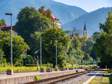 Kamnik, Slovenya - 8 Ağustos 2025: Slovenya 'nın Kamnik kentinde arka planda dağlarla birlikte kırsal bir tren istasyonunun manzarası.