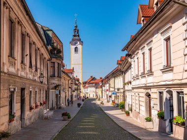 Kamnik, Slovenya - 8 Ağustos 2025: Tarihi binaları ve kilise kulesi olan Sloven Kamnik caddesi.