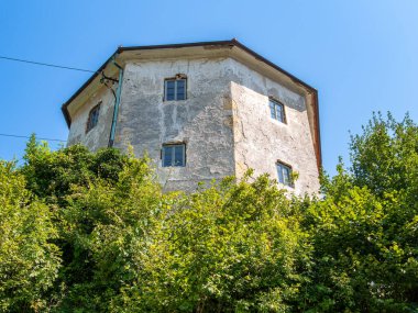 Kamnik, Slovenya - 10 Ağustos 2025: Sekizgen şekilli eski taş bina yeşillikle çevrili.