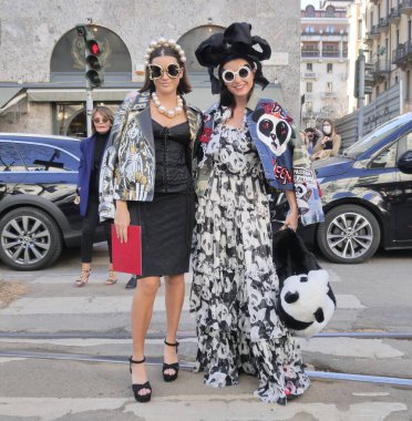   Milano Moda Haftası kadın koleksiyonu 2022 'de Dolce & Gabbana defilesinden önce fotoğrafçılara poz veren moda blogcuları