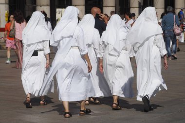 Beyaz elbiseli, Duomo Meydanı 'nda yürüyen beş rahibe, Milan, İtalya