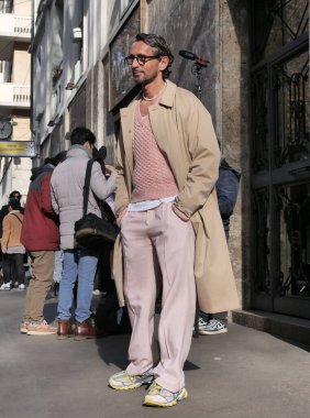  DOlce & Gabbana defilesinden önce, MFW 2023 erkek koleksiyonları sırasında fotoğrafçılara poz veren modacı..