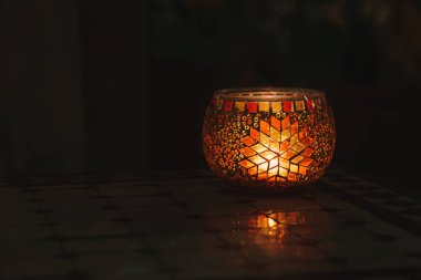 Fas 'ın son derece dekoratif feneri, bir fayans masasının üzerinde, karanlıkta parlıyor..
