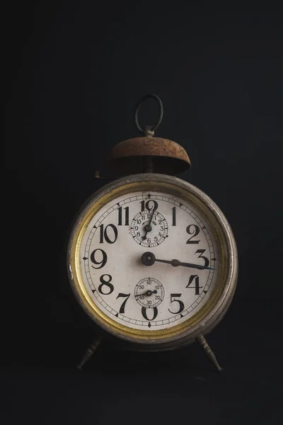 Old Vintage Alarm Clock set against dark background with copy space. Rusty and antique traditional clocks.