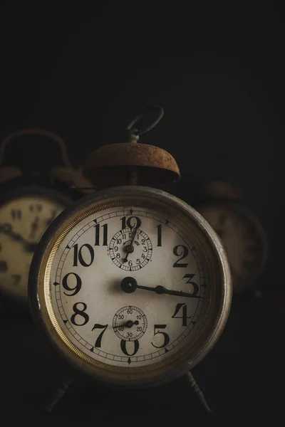 Old Vintage Alarm Clock set against dark background with copy space. Rusty and antique traditional clocks.