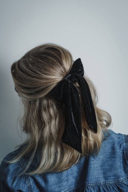 Back of young womans head showing blonde brow hair against white background. Copy space available.