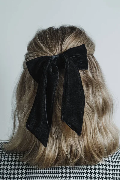 Back of young womans head showing blonde brow hair against white background. Copy space available.