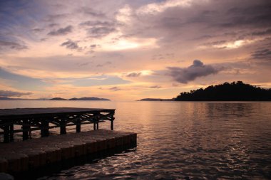 Raja Ampat Endonezya sahilinde gün batımının güzelliği ve turist ifadelerinin siluetleri. Raja Ampat, uluslararası turizm merkezi olarak belirlenen turlardan biri..