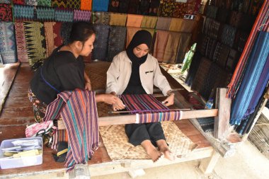 Sade Köyü, Lombok, Batı Nusa Tenggara, Endonezya 'daki Sasak kabilesine özgü geleneksel kumaş örmeyi öğrenin. Sade Köyü güzel bir turist köyüdür..