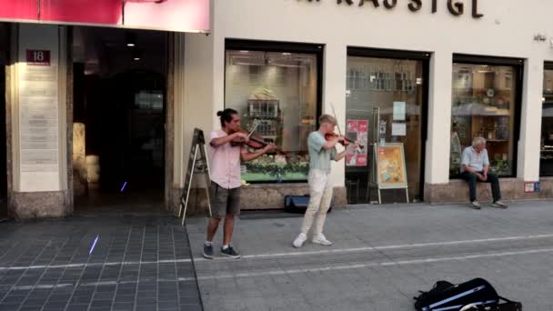 インスブルック オーストリア 2023年8月22日 2人のミュージシャンがインスブルック市中心部のアルトシュタット広場でバイオリンを弾く — ストック動画