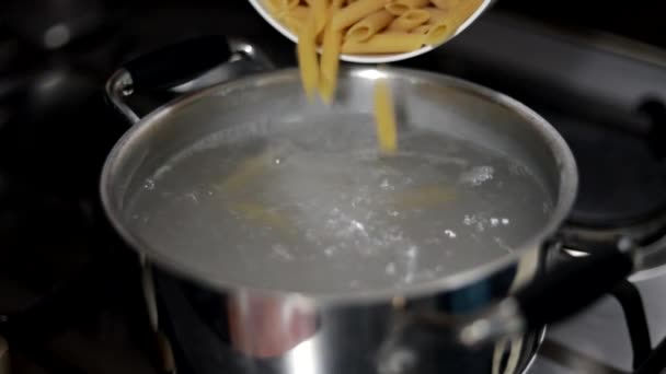 沸騰した水の鍋にパスタを注ぐ — ストック動画