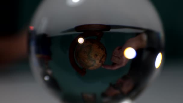 Человек Вращает Глобус Пальцем Перевернутый Вид Через Стеклянную Сферу — стоковое видео