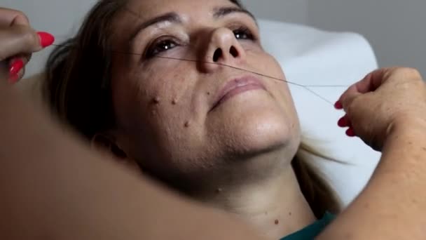 Den Kosmetolog Utför Kvinnas Ansiktshår Avlägsnande Med Hjälp Den Antika — Stockvideo