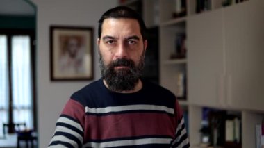 Sakallı adam ciddi bir ifadeyle evde parmaklarıyla hayır diyor..