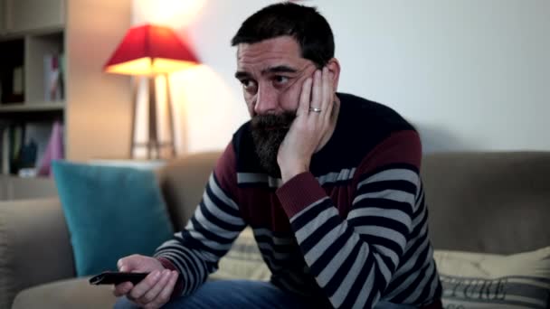 Bearded Man Holding Remote Control Watching Sitting Sofa Boring Expression — Stock Video