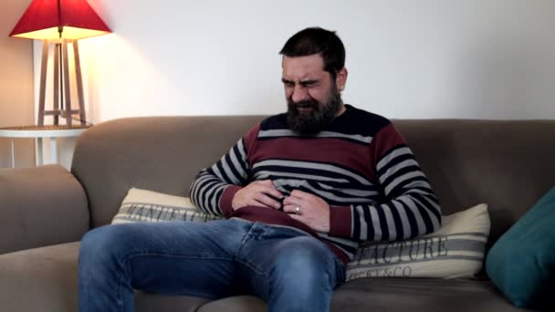 Άντρας Που Υποφέρει Από Στομαχόπονο Κάθεται Στον Καναπέ Στο Σπίτι — Αρχείο Βίντεο