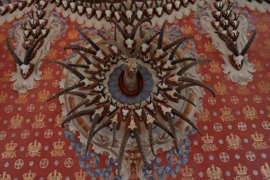 Aosta Valley, Italy - August 17, 2024: A detail on the wall of the Trophy Hall made with hundreds of ibex horns inside the Royal Castle of Sarre in Aosta Valley, Italy. clipart