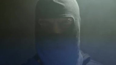 Karanlıkta flaş ışığı ve dumanı olan siyah kar maskeli bir hırsıza yaklaş. Başka birinin evine giren bir hırsız..