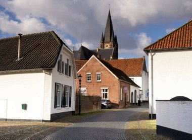 Limburg 'daki beyaz Thorn kasabasındaki kilise kulesi manzaralı cadde.