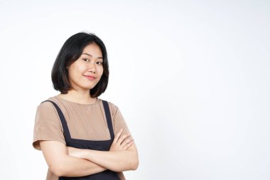Çapraz kollar, gülümse ve beyaz arka planda yalnız bırakılmış güzel Asyalı kadının kamerasına bak.