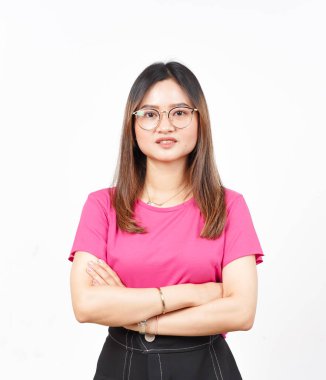 Kollarını kavuşturup gülümsüyor ve beyaz arka planda izole edilmiş güzel Asyalı kadının kamerasına bakıyor.