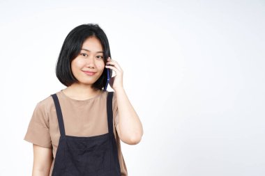 Beyaz arka planda izole edilmiş güzel Asyalı bir kadının mutlu yüzüyle akıllı telefondan konuşmak.