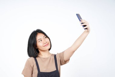 Beyaz arka planda izole edilmiş güzel Asyalı kadının akıllı telefonuyla bir selfie çek.