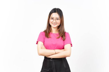 Beyaz arka planda yalnız bırakılmış güzel Asyalı kadının kollarını kavuşturup kameraya bakıyor ve gülümsüyor.