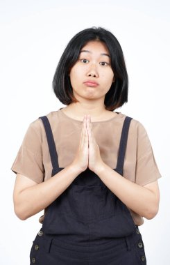 Beyaz arka planda tecrit edilmiş güzel Asyalı kadından özür dilemek için yalvarıyor.