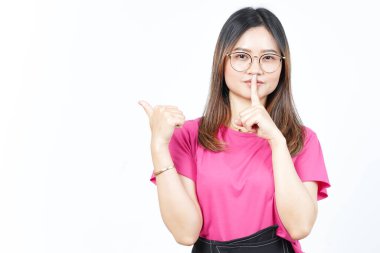 Shh gesture, Presenting and Pointing Side Product Using Thumb Of Beautiful Asian Woman